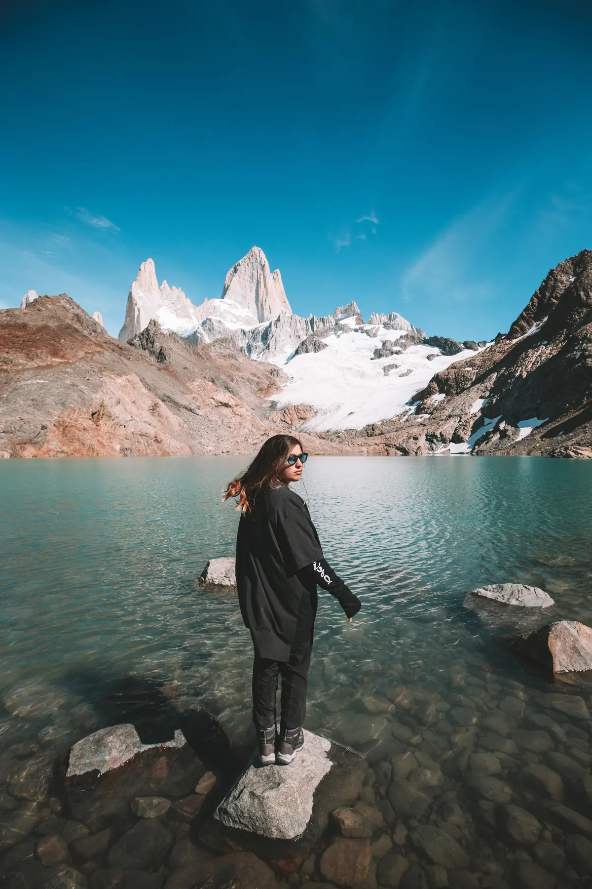 Standing on a rock in the lake, facing the massif