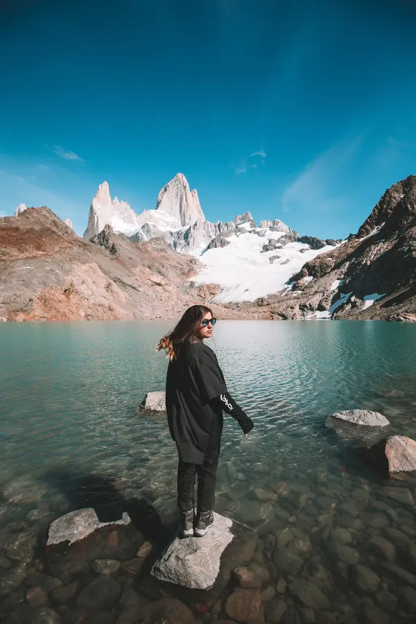 Standing on a rock in the lake, facing the massif